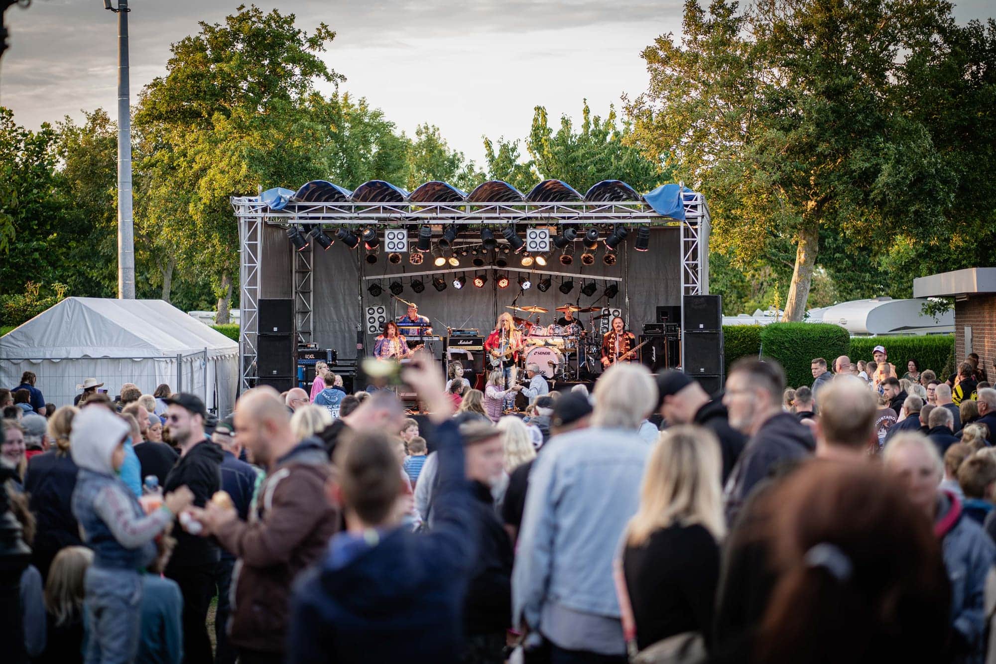 Bühne auf der Festwiese mit Publikum am frühen Abend