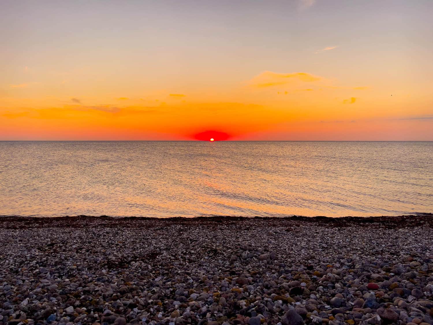 Abendrot über dem Kiesstrand