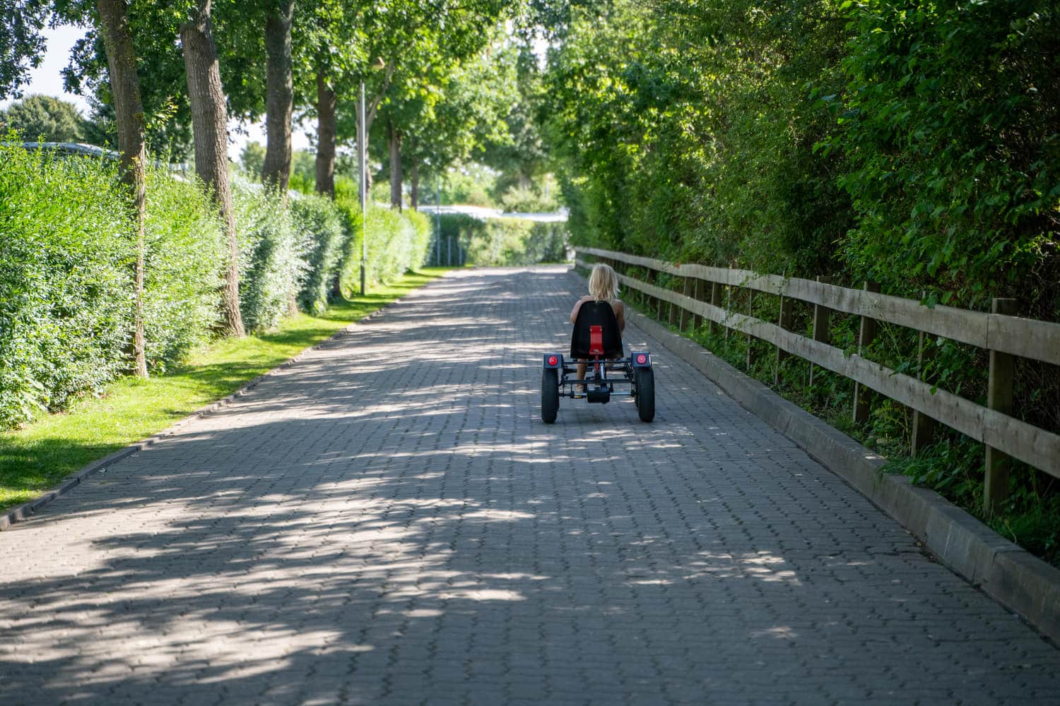 Kind mit Kettcar auf dem Weg über den Platz