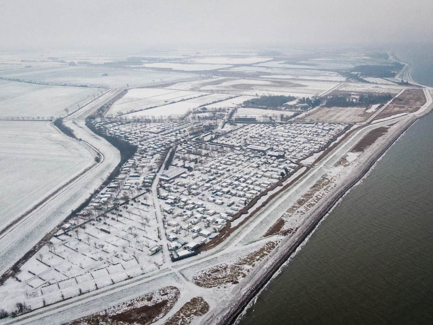 Luftbild des verschneiten Campingplatzes im Winter