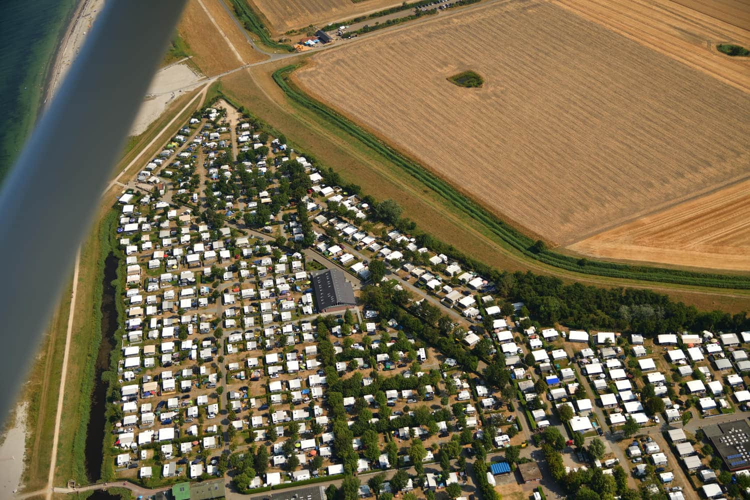 Luftbild des Wasserlaufs über den Platz bis zum Strand