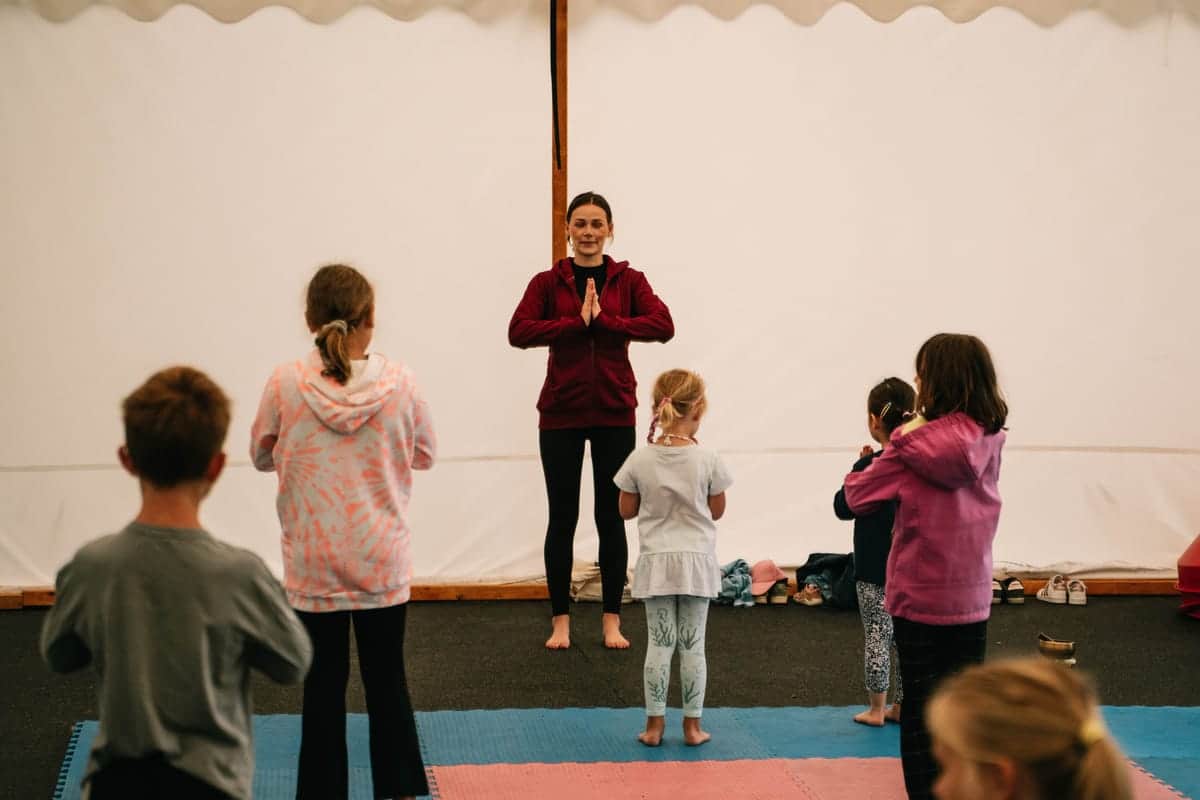 Kinder beim Kinderyoga im Zelt mit der Übungsleiterin