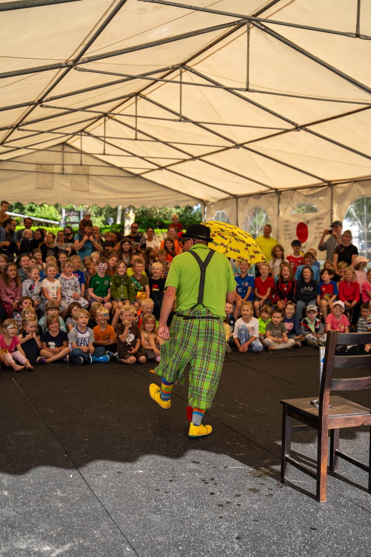 Kinder sitzen im Zelt vor der Bühne bei der Zaubershow