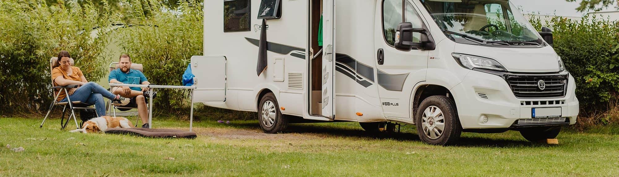 Wohnwagen mit Vorzelt auf einem heckenparzellierten Stellplatz im Grünen