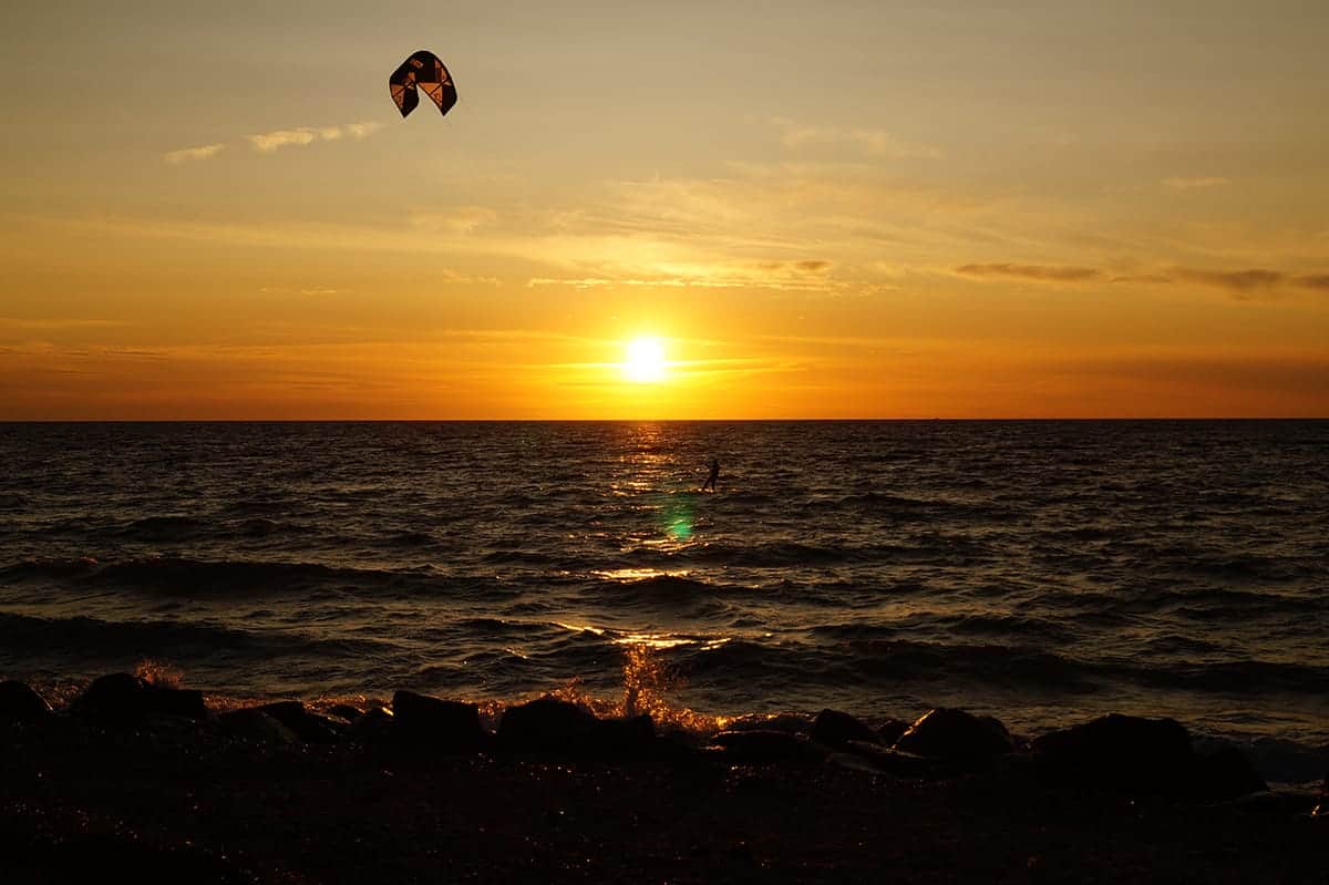 Kitesurfer vor der untergehenden Sonne über der Ostsee