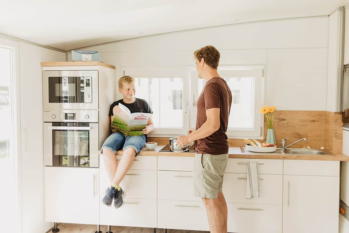 Vater und Sohn in der Einbauküche eines Mietwohnwagens