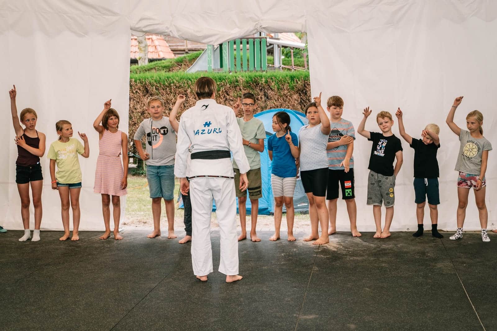 Kinder in einer Reihe beim Jiu-Jitsu-Training mit dem Trainer